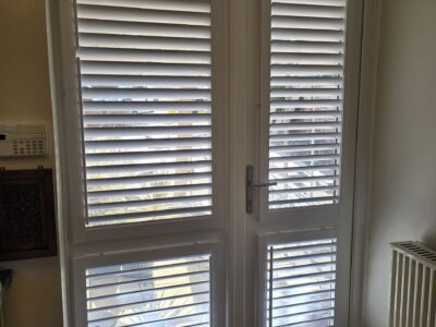 White plantation shutters on a bay window fitted by JV Blinds