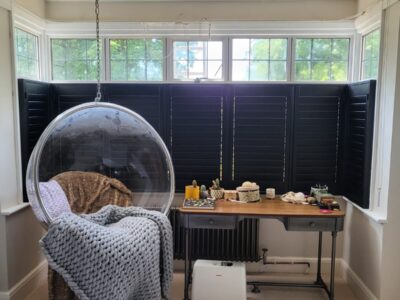 Bay window shutters in a dining room fitted by JV Blinds