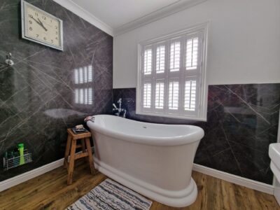 White shutters in a bathroom, waterproof ABS material by JV Blinds